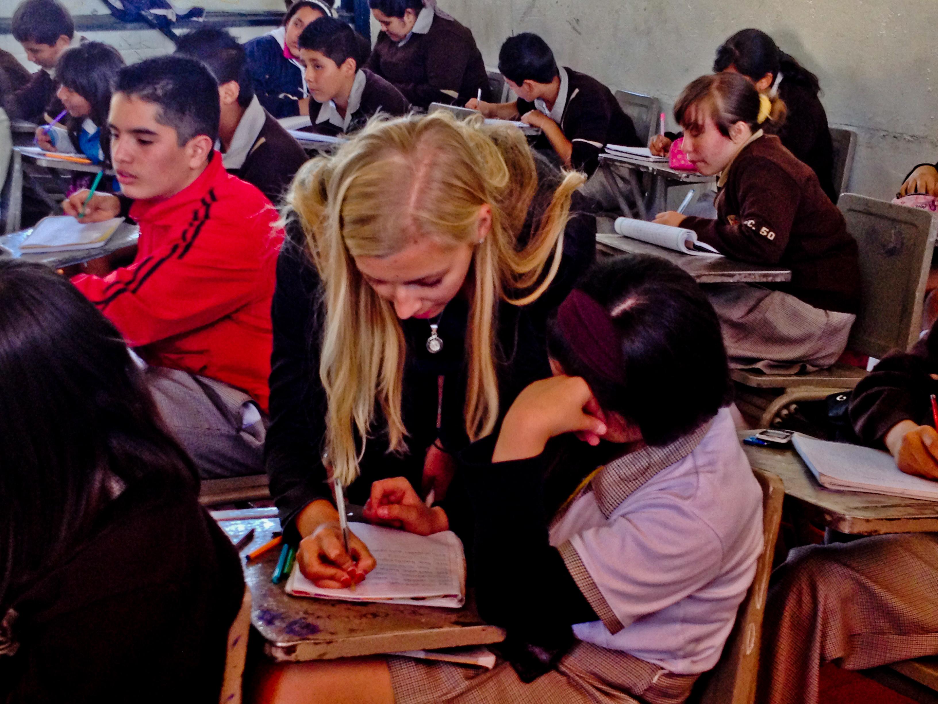 A Projects Abroad volunteer helps a student with her classwork during her teaching work experience in Mexico A volunteer teaching English in Mexico goes around the class helping her students with their classwork
